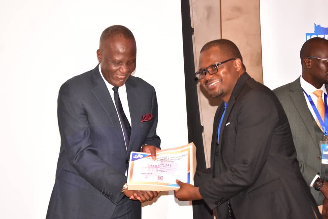 Prof. Aaron Zimba receiving an ICTAZ fellowship certificate